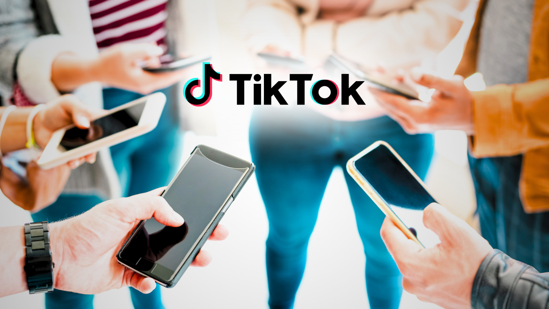 Das Bild zeigt mehrere Menschen, die in einer Gruppe zusammenstehen und auf ihre Smartphones schauen. Über ihnen ist das bekannte TikTok-Logo zentriert dargestellt. Die Personen sind größtenteils unscharf, während die Smartphones im Vordergrund scharf abgebildet sind, was den Fokus auf die digitale Vernetzung und Nutzung von TikTok legt.